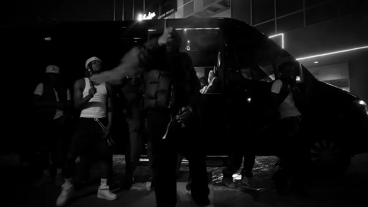 A group of people gathering around a van at night, some of whom are dancing. Thumbnail for "Medikal - Pass 2 (Official Video)"
